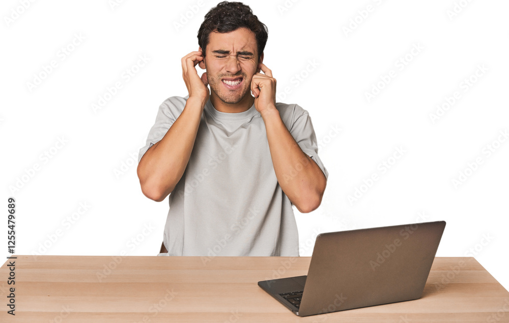 Hispanic young man working on laptop covering ears with hands. Hispanic young man working on laptop covering ears with hands.