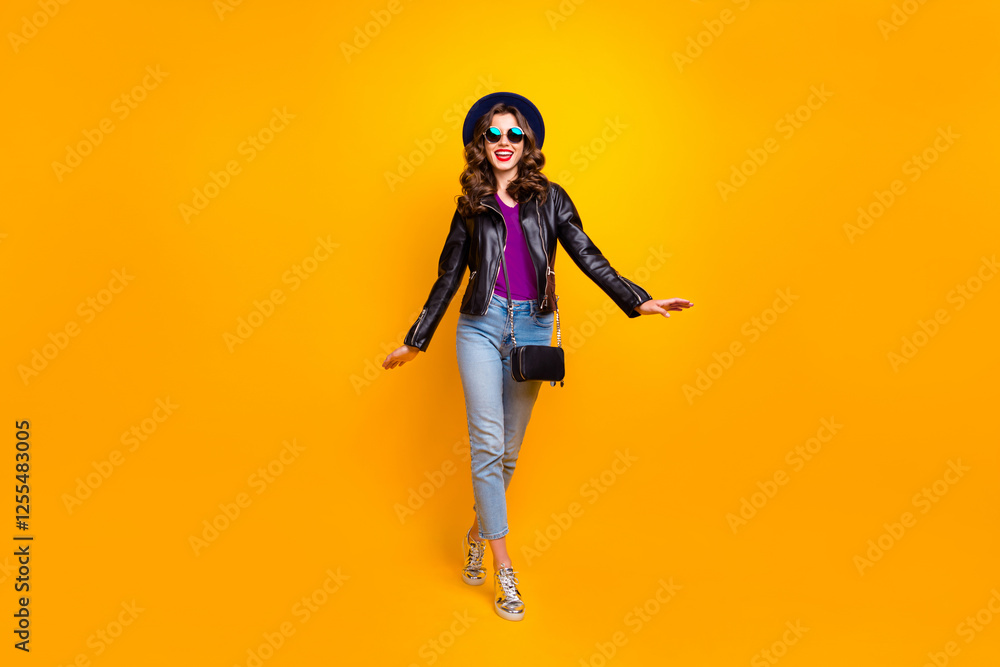 Full body photo of cute pretty girl walking with her friends on spring holidays wear modern black leather jacket denim jeans isolated over yellow color background Full body photo of cute pretty girl walking with her friends on spring holidays wear modern black leather jacket denim jeans isolated over yellow color background