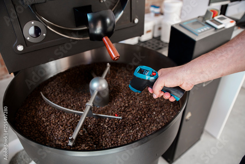 A man checking the temperature of roasted coffee beans in Barcelona, Spain photo