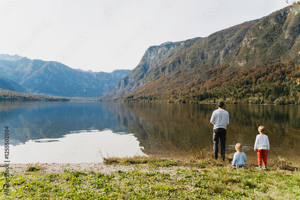 Father and children spending leisure time near mountain lake Father and children spending leisure time near mountain lake