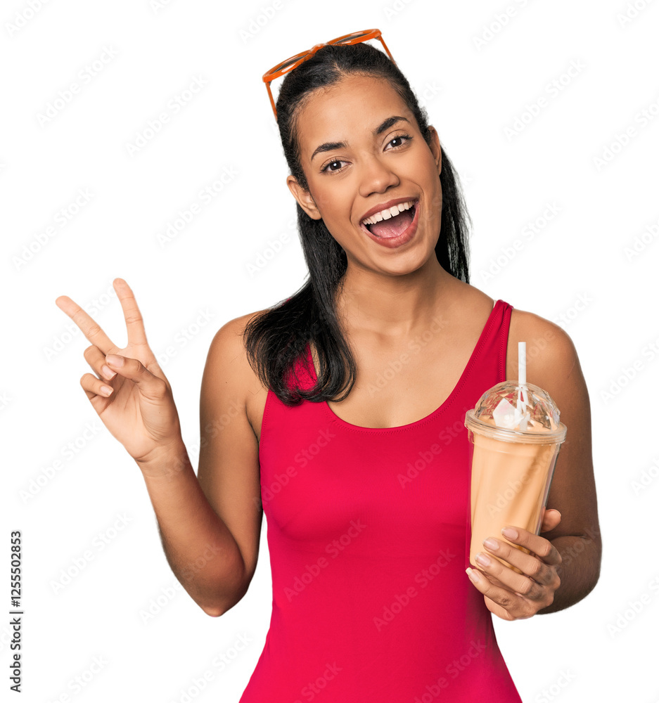 Young Filipina with smoothie joyful and carefree showing a peace symbol with fingers. Young Filipina with smoothie joyful and carefree showing a peace symbol with fingers.