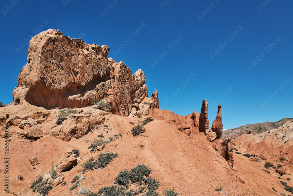 Fototapeta premium Fairy Tale Canyon on the southern shore of Issyk-Kul lake, Kyrgyzstan. Picturesque travel destination, landmark Kirgiziya. Summer skazka canyon with colorful rocks and hills. Natural park landscape