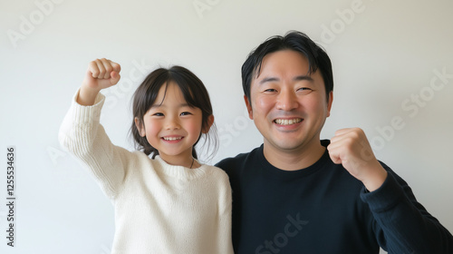 Obraz na płótnie 日本人の小学生の娘と40代の父親が笑顔でガッツポーズしているツーショット写真 上半身 w salonie