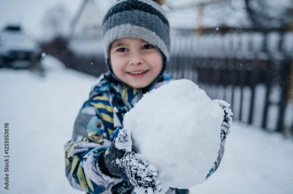 Smiling boy holding snowball in winter Smiling boy holding snowball in winter