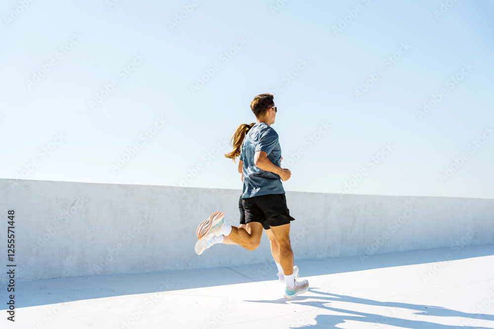 Couple enjoys a morning jog together on a sunny day at an outdoor track Couple enjoys a morning jog together on a sunny day at an outdoor track