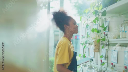 Eco friendly shop owner using  notebook to check bio organic products stock in container dispenser at plastic free grocery store. Sustainable small local business SME startup go green market.