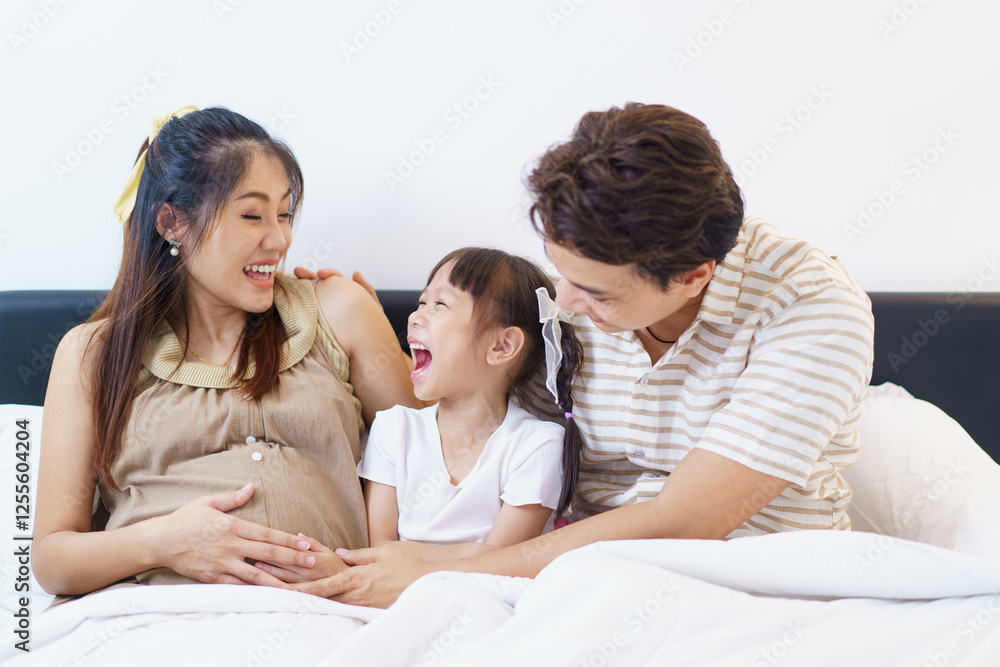 Happy Asian family relaxing together on a bed. Happy Asian family relaxing together on a bed.