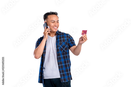 Wallpaper Mural Portrait of Asian Indonesian man in shirt talking on mobile phone while showing his credit card isolated over white background. Copy space or mockup. Concept of technology, communication, or shopping Torontodigital.ca