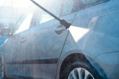 Fotografie Car being washed at a drive-through car wash during a sunny afternoon