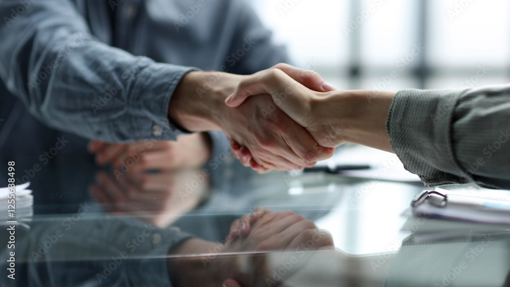 Obraz premium Document discussion and handshake at the desk in close-up in the office