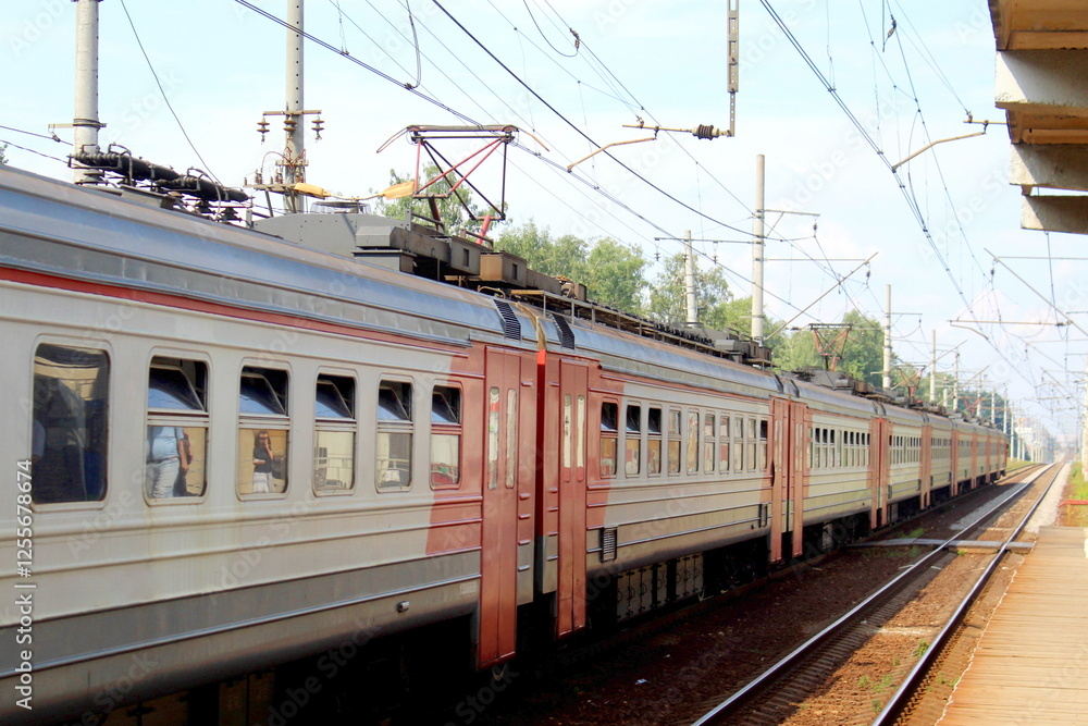 In summer, the electric train stands at the station. In summer, the electric train stands at the station.