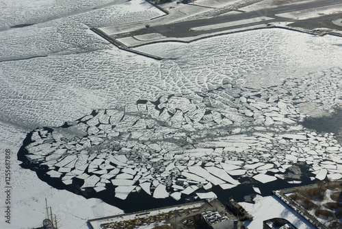 Photography Aerial view of the frozen, snow-covered ice on Lake Ontario along the shoreline of the city of Toronto, Canada