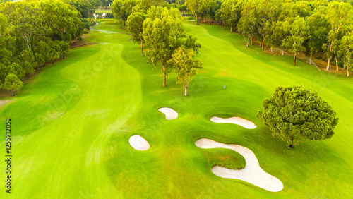 An aerial view of a pristine golf course with sand traps and lush greenery