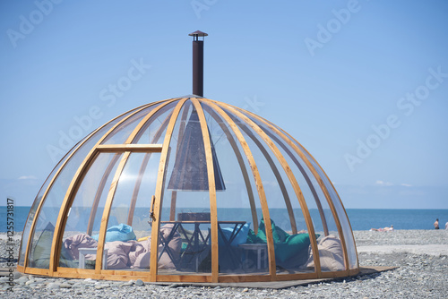 Transparent bubble dome on the seashore on fine sand. The perfect place to relax. With space to copy. High quality photo