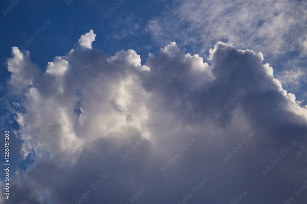 Fotografie A celestial landscape with voluminous clouds and bright sun flares