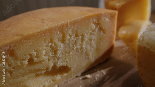Large pieces of hard cheeses in close-up. Delicious cut of aged cheese in the sun. Cheese texture, tasting of the most delicious types of cheese, natural product.