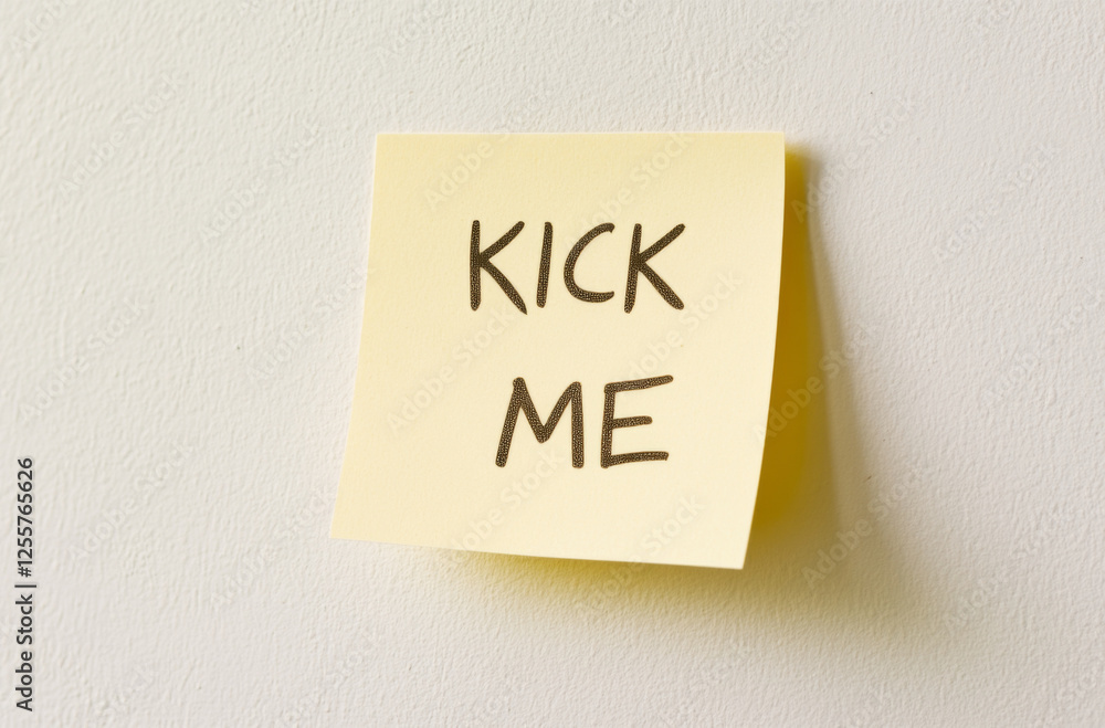 April Fools concept with kick me yellow note and marker on white background April Fools concept with kick me yellow note and marker on white background
