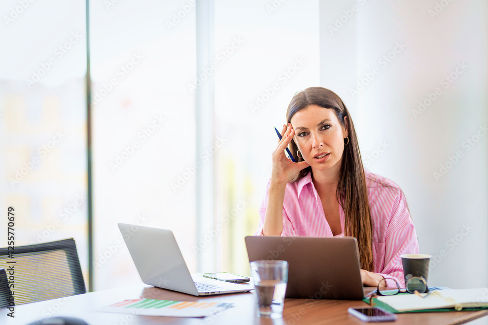 Woman sitting at desk and using laptops in a modern office Woman sitting at desk and using laptops in a modern office