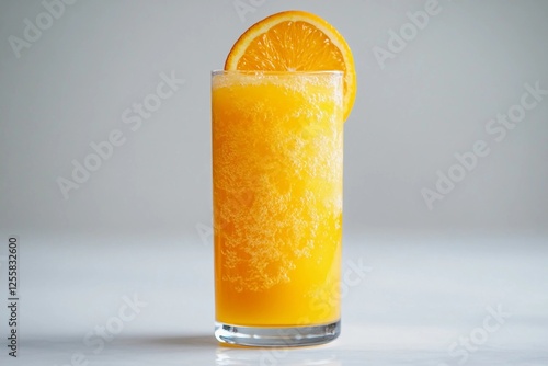 Refreshing citrus drink served in a glass, showcasing vibrant orange hue and garnished with a slice of fresh orange photo