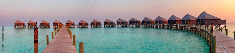Wide panoramic view of water villas on Komadoo in the Maldives. Wide panoramic view of water villas on Komadoo in the Maldives.