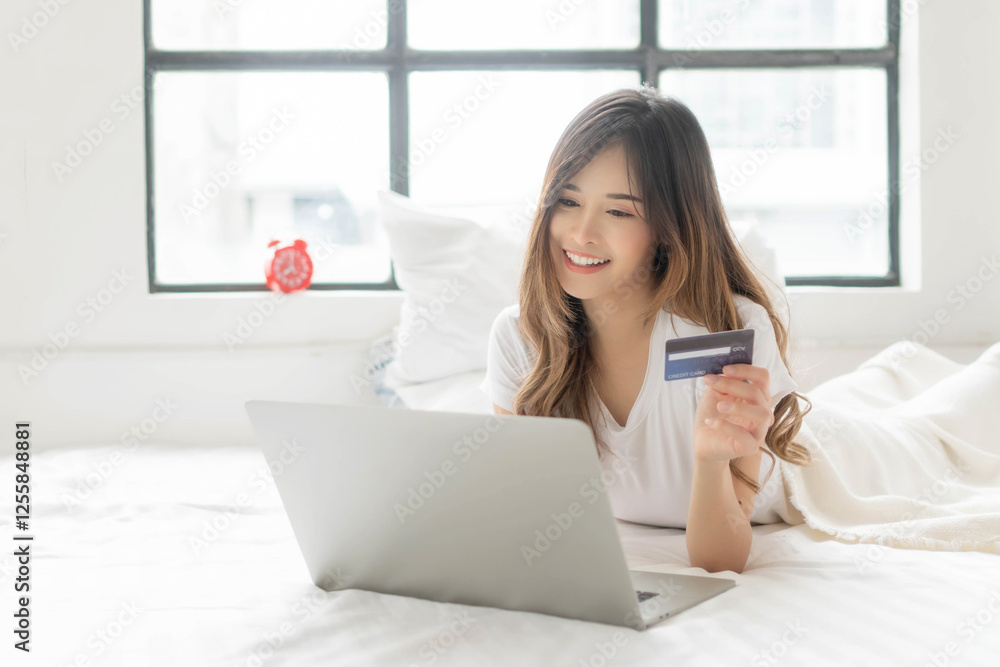Smiling Young Asian Woman Online Shopping at Home, Using Laptop and Credit Card in Bright Room, E-commerce, Digital Payment, and Convenient Lifestyle Concept Smiling Young Asian Woman Online Shopping at Home, Using Laptop and Credit Card in Bright Room, E-commerce, Digital Payment, and Convenient Lifestyle Concept