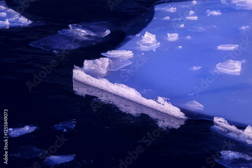 Big beautiful ice floe in dark deep winter water