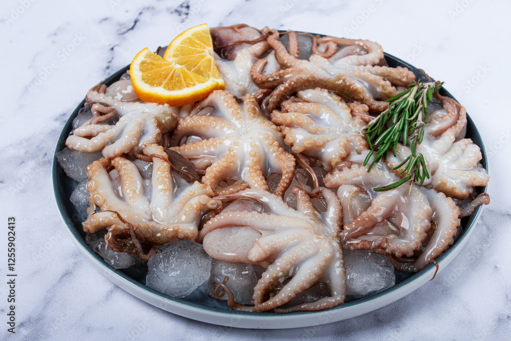 Fresh baby octopuses on ice, garnished with lemon and rosemary, on a marble table, no people, Fresh baby octopuses on ice, garnished with lemon and rosemary, on a marble table, no people,