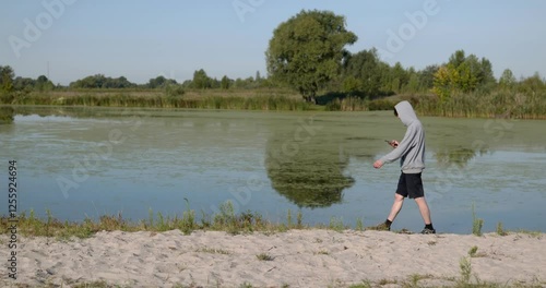 Wallpaper Mural Caucasian Man Walks With Smartphone Near River. Hiking on Nature. Slow motion 60fps 4K 10-bit Torontodigital.ca