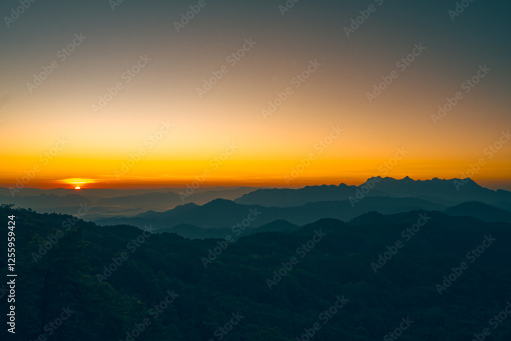 High-angle view of a beautiful orange, pink, and yellow sky as the sun rises with copy space on top. Doi Luang Chiang Dao is on the right side, which has an unusual shape. Feeling free and peaceful. High-angle view of a beautiful orange, pink, and yellow sky as the sun rises with copy space on top. Doi Luang Chiang Dao is on the right side, which has an unusual shape. Feeling free and peaceful.