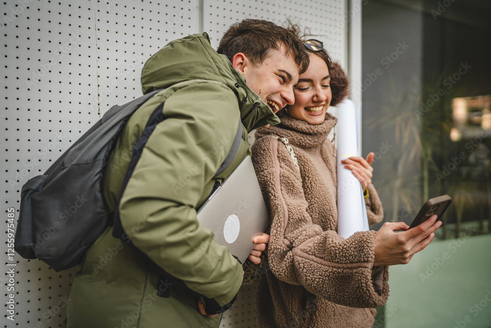 Fototapeta premium couple stand in front white wall and use cellphone before university