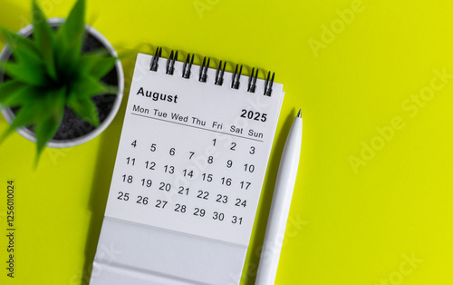 Desk calendar for August 2025 on a yellow background.