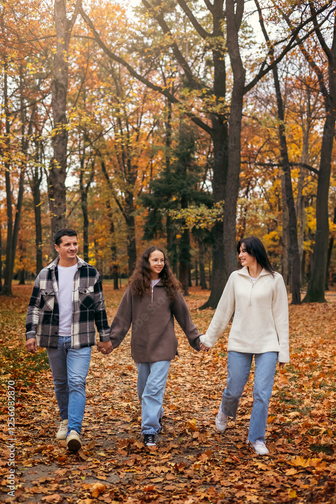 Family Walking Through Autumn Leaves in Scenic Park Family Walking Through Autumn Leaves in Scenic Park