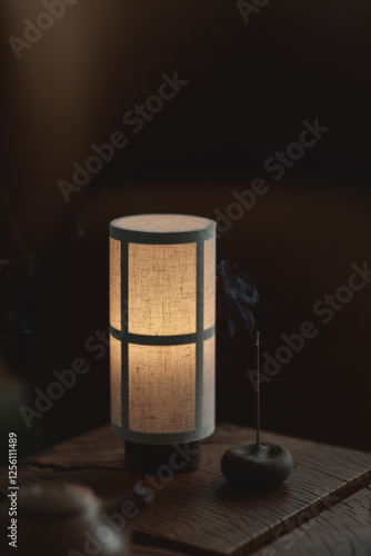 Aesthetic incense stick with smoke. Spa meditation concept. Japanese portable lamp with linen textures.