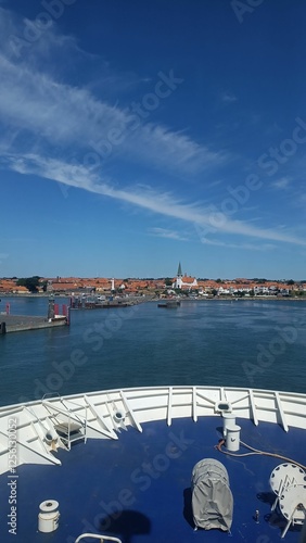 Schiff kurz vor einem Hafen, schöne Aussicht auf malerischen Ort, rote Ziegeldächer, blauer Himmel an einem schönen Sommertag, Meer und Hafen photo