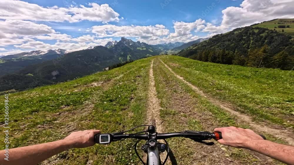 Point of view of a person riding mountain e-bike with scenic mountain view. Freedom concept of a tourist man riding a bicycle on mountain trail. Travel summer activities in Swiss Alps