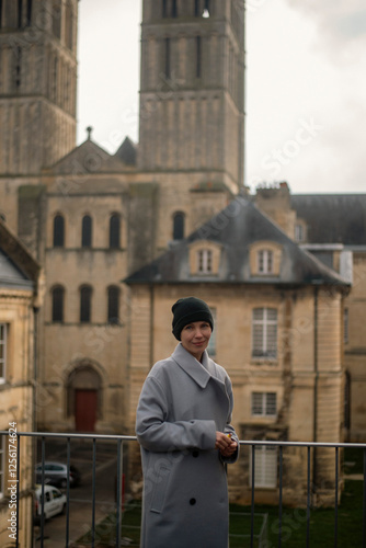 Wallpaper Mural Female caucasian adult in gray coat posing near historic stone architecture Torontodigital.ca