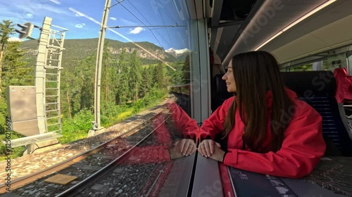 Lifestyle video of a tourist woman traveling on Bernina Express panoramic train with a stunning view of the Alps. Perfect for lifestyle, travel, vacation, and adventure in the Swiss Alps