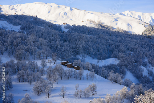 Scenic View of snow-covered stone cabins in alpine landscape. Les Menuires. French Alps.  France photo