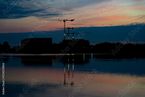 Baustelle mit Kränen im Abendlicht