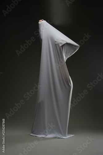 Vászonkép Sensual woman playfully draped in sheer fabric in a dimly lit space