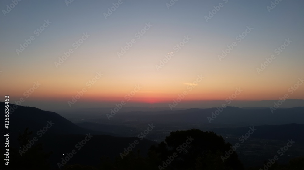 Serene Sunset Over Mountains and Valleys in Calm Evening Sky Serene Sunset Over Mountains and Valleys in Calm Evening Sky