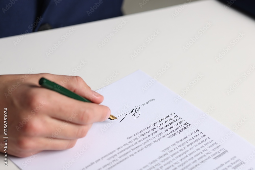 Man putting signature on document at white table, closeup Man putting signature on document at white table, closeup