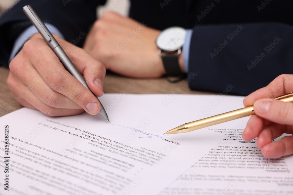 Woman pointing at document and man putting signature at table, closeup Woman pointing at document and man putting signature at table, closeup