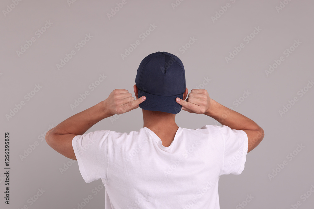 Man in stylish baseball cap on grey background, back view. Mockup for design Man in stylish baseball cap on grey background, back view. Mockup for design