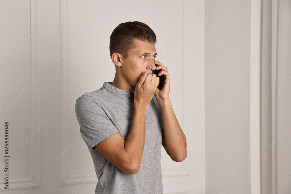 Stressed man calling hotline for mental health help indoors