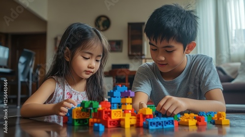 Elder brother and younger sister playing with toy building blocks in the living room, enjoying creative games and sibling bonding