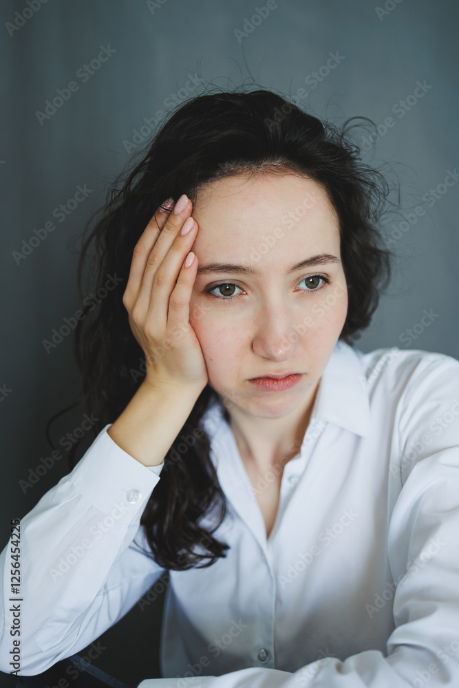 A woman looks uncomfortable yet thoughtful, lost in her contemplation of her feelings A woman looks uncomfortable yet thoughtful, lost in her contemplation of her feelings