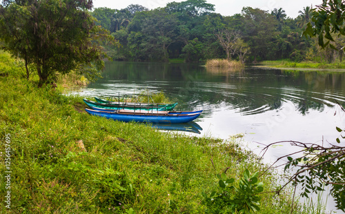 Empty blue catamaran on Hiriwadunna lake, Sigiriya, Sri Lanka