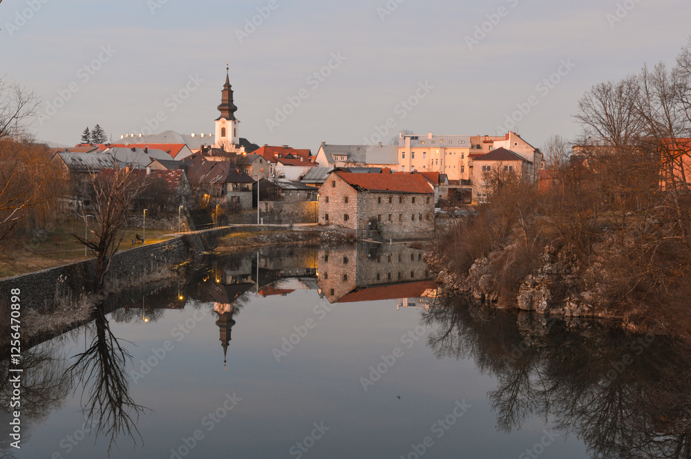 Naklejka premium Gospic town panorama with river Novcica reflection