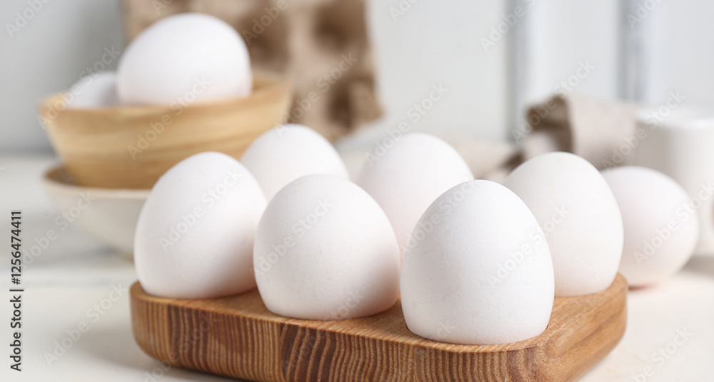 Wooden holder with raw chicken eggs on white background Wooden holder with raw chicken eggs on white background
